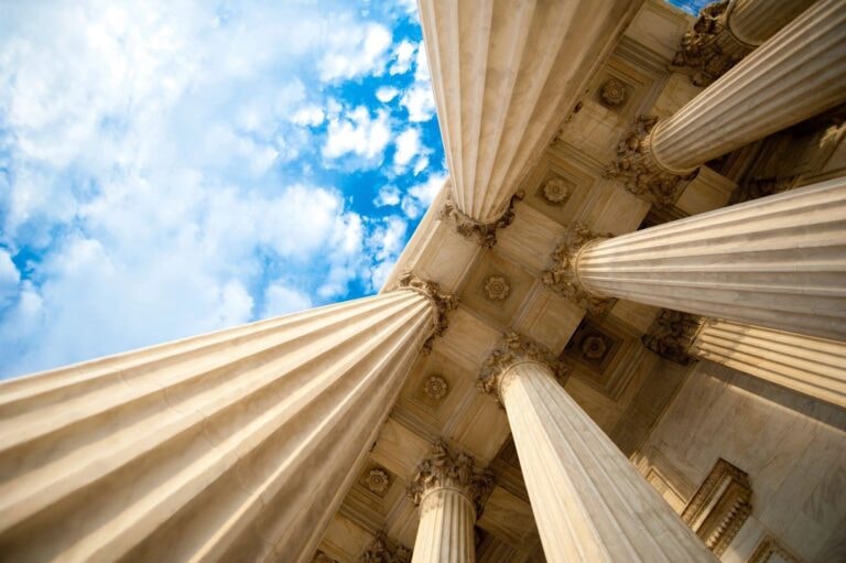 Classical courthouse columns against blue sky